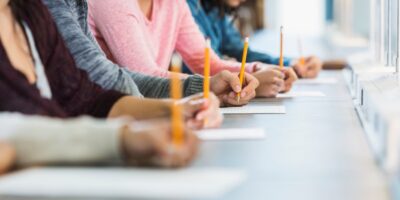 students writing with pencils