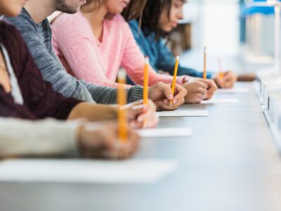 students writing with pencils