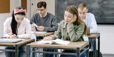 four students at desks in a classroom